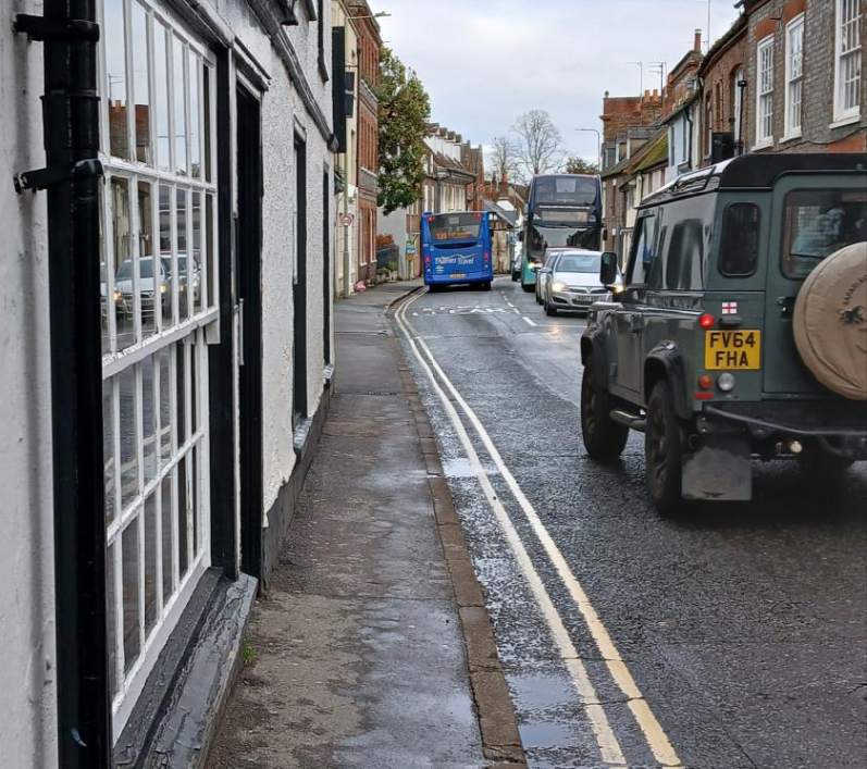 St Mary's Street, Wallingford Narrow street with a grey vehicle, a blue bus, and buildings along the pavement.